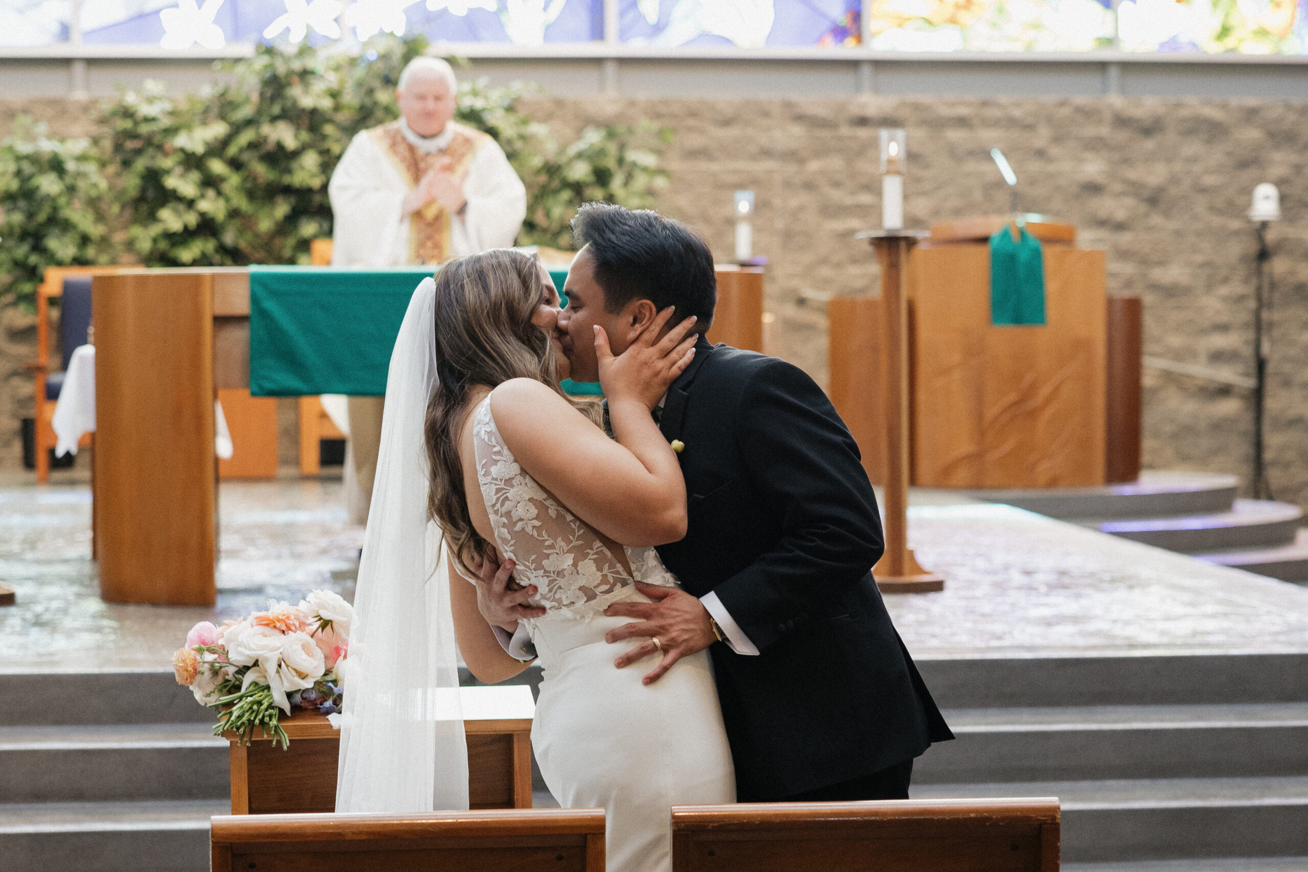 A bride and groom celebrating mass on their wedding day at St. Thomas More church in Arizona