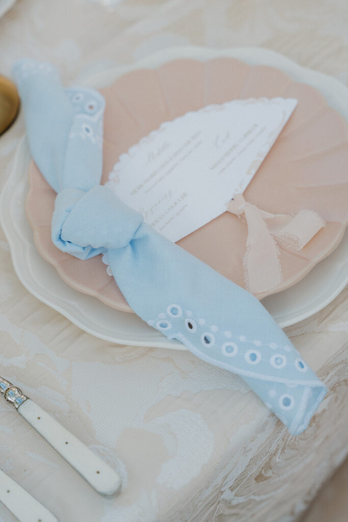 Fan-shaped menus and soft linens adding thoughtful details to a butter yellow wedding tablescape.
