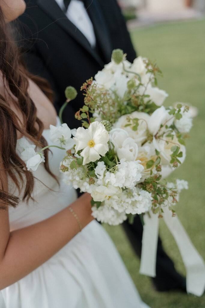 Bride holding a bouquet of soft florals, the perfect accent for a butter yellow wedding.